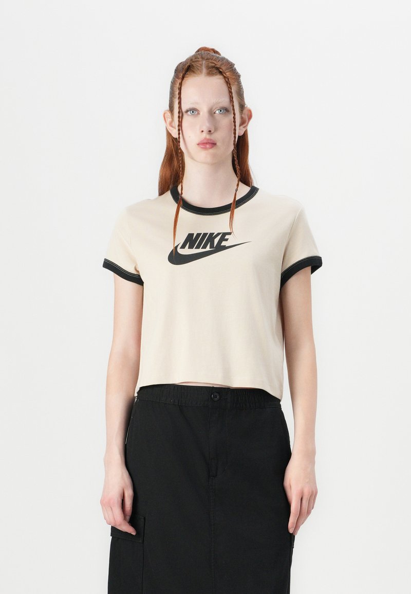Kremfarget kortermet t-skjorte med svart ringer rundt hals og armer, med en fremtredende svart Nike-logo sentrert på brystet.