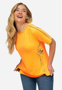 Heldere oranje T-shirt met korte mouwen, gemaakt van zachte katoen. Heeft een zwarte lijntekening aan de zijkant en contrasterende stiksels langs de schouders.