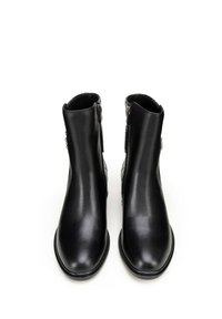 Botas de tobillo de cuero negro con una textura suave, punta redondeada y cremalleras laterales para el cierre. Diseño minimalista con una silueta elegante.