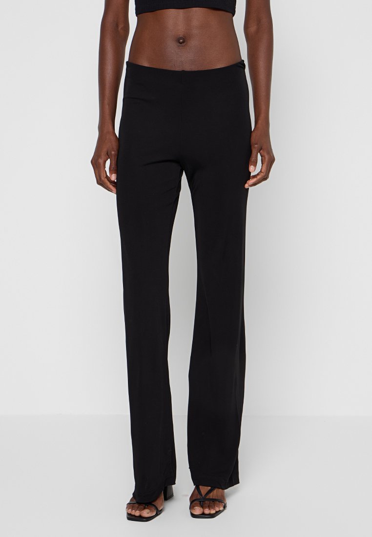 Pantaloni neri aderenti con un design a gamba dritta, realizzati in un tessuto morbido e elasticizzato. La vita si trova comodamente all'altezza della vita naturale.