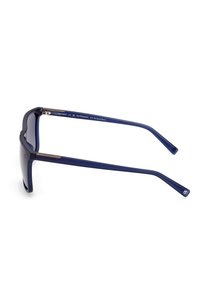 Gafas de sol azules hechas de un 65% de plástico de base biológica. Montura rectangular elegante con lentes oscuros y acentos metálicos en las bisagras.
