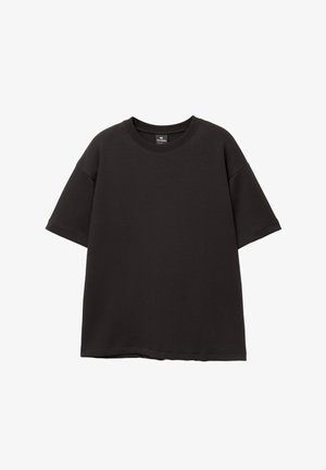 Črna oversize majica iz bombaža, z okroglim izrezom in kratkimi rokavi ter gladko teksturo, brez vidnih vzorcev ali poudarkov.