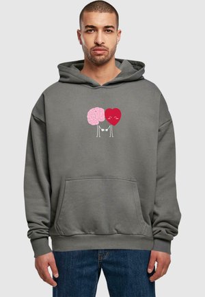Grå hættebluse med grafik af en pink hjerne og et rødt hjerte, der holder hænder, med en frontlomme i kenguru-stil og afslappet pasform.