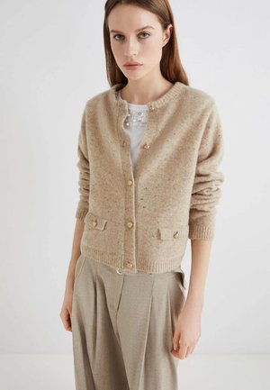 Cardigan in lana beige con collo rotondo, cinque bottoni dorati e due tasche frontali. La trama è morbida con un leggero motivo a macchie.