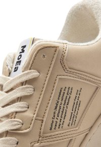 Tuvojoties beidge kedai, ar auduma šņorēm, piešūtām paneļiem un tekstu, kas izceļ ekoloģiskās, dzīvniekiem draudzīgās un pārstrādātās materiālu īpašības.