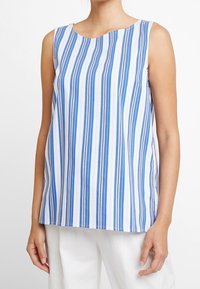 Top senza maniche con strisce verticali blu e bianche e sottili dettagli marroni. Tessuto liscio con scollatura arrotondata e orlo dritto.