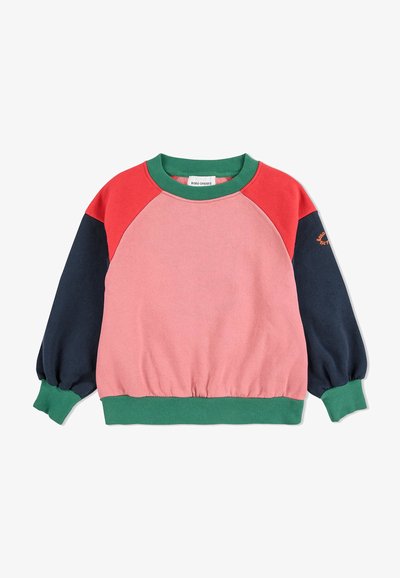 Vaaleanpunainen, punainen ja laivastonsininen raglan-hihainen collegepaita, jossa on vihreät ribbikamitan ja helman yksityiskohdat; valmistettu pehmeästä puuvillasta, joka istuu rentoon tyyliin. Huomionarvoinen logo-yksityiskohta hihassa.