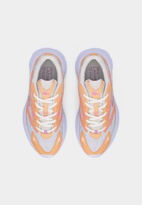 Ζευγάρι αθλητικών παπουτσιών δέσιμο κορδονιών σε πορτοκαλί, λευκό και μωβ χρώμα, με ύφασμα από δίχτυ και χοντρές σόλες, απεικονιζόμενα από πάνω σε λευκό φόντο.