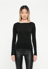 Zwarte langarmtop met een bootnek, voorzien van verspreide rhinestones. Gladde textuur, slim fit, gecombineerd met glanzende zwarte broek.