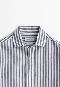 Chemise à col avec boutons, rayures verticales bleu marine et blanches, en tissu coton lin.