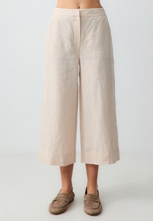 Linen culotte pants in pale beige with a wide-leg design, featuring a smooth texture and a hem that falls just above the ankles.
