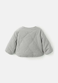 Giacca grigia trapuntata con scollatura rotonda, spalle abbassate e maniche lunghe e voluminose. Presenta un motivo testurizzato sul tessuto.