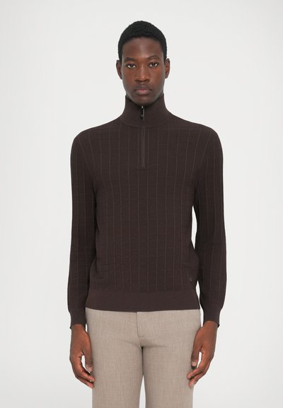 Pull en maille côtelée marron avec un col haut et une courte fermeture éclair. Présente un motif à carreaux discret et une silhouette ajustée.