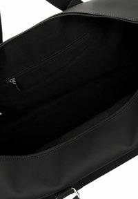 Black tote bag with a smooth, matte exterior. Interior features a zippered pocket. Simple design with a flat shape and sturdy stitching.