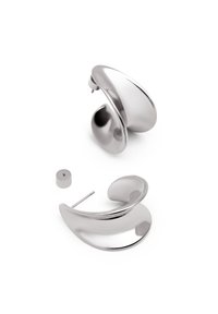 Pendientes de metal plateado con un diseño curvado y fluido. Un pendiente cuenta con un stud de poste y un respaldo removible. Superficie lisa y reflectante.