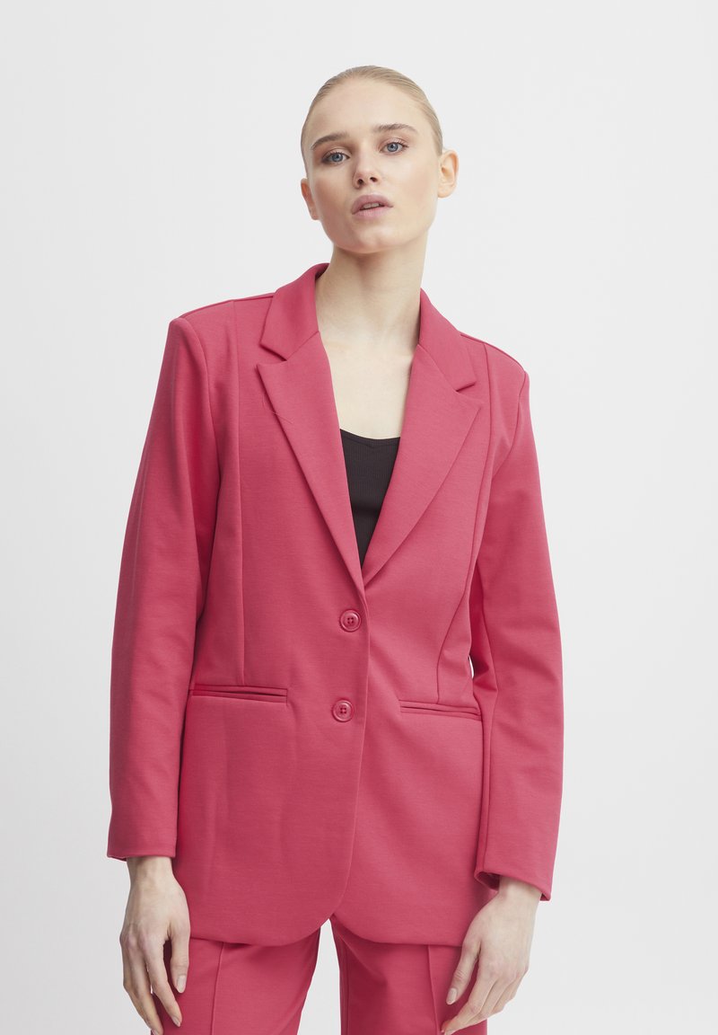 Rosa maßgeschneiderte Blazer mit Reverskragen, zwei vorderen Knöpfen und seitlichen Taschen. Hergestellt aus glattem Stoff mit strukturiertem Schnitt.