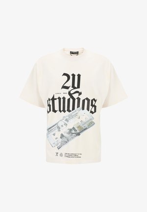 Kremai krāsā izgatavota kokvilnas T-kreklā ar brīvu piegriezumu, uz kura priekšpuses redzams liels melns teksts "2Y studios" un valūtas grafika.