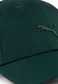 Donkergroene pet van textiel met structuur. Voorzien van een gestikt patroon, een gebogen rand en een donkergroene geborduurde logo aan de voorkant.