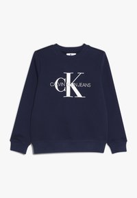 Puuvillainen laivastonsininen collegepaita, jossa pitkät hihat, pyöreä kaula-aukko ja suuri valkoinen "CK"-logo sekä "CALVIN KLEIN JEANS" -teksti alapuolella.