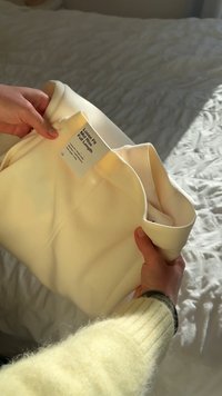 Brīvi pieguļoši krēmkrāsas bikses ar vidēja augstuma jostasvietu un pilna garuma kājām. Faktūrēta etiķete ar auduma kopšanas norādījumiem.