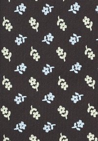 Brązowy materiał o prążkowanej fakturze, z małymi niebieskimi i kremowymi wzorami kwiatowymi równomiernie rozmieszczonymi w całym wzorze.