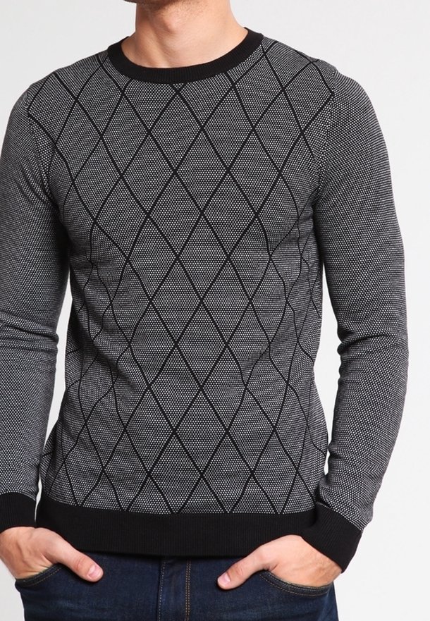 Pull noir et blanc à motif losange, avec poignets et ourlet côtelés, fabriqué en tissu tricoté texturé.