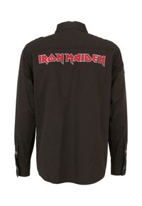 Fekete, hosszú ujjú ing, amelyen a "IRON MAIDEN" felirat vastag piros és fehér betűkkel látható a háton. Gombos mandzsetta és gallér.