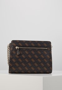 Černá crossbody kabelka se vzorem a zlatými detaily, která má přední zipovou kapsu a řetízkový popruh. Texturovaný materiál a design loga po celé kabelce.