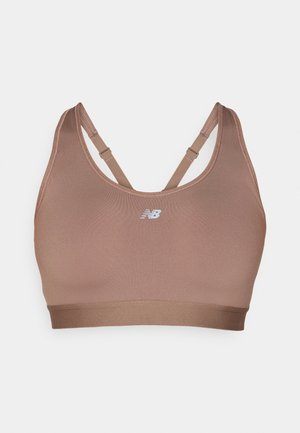 Soutien-gorge de sport dans une teinte brune atténuée, fabriqué en tissu lisse. Dispose de bretelles croisées réglables et d'un logo au centre à l'avant.