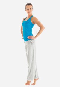 Sportliches Outfit mit einem blauen ärmellosen Oberteil und hellgrauen Jogginghosen mit Kordelzug. Der Stoff scheint weich zu sein und das Design hat eine lockere Passform.