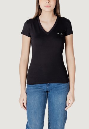 Maglietta nera a maniche corte con scollo a V realizzata in cotone morbido, con un piccolo logo sul lato sinistro e un design aderente. Abbinata a jeans blu.