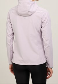 Ljuslila huva-jacka med en slät textur och en figursydd design. Har ett reflexlogotyp och kontrasterande grå trim vid ärmsluten.