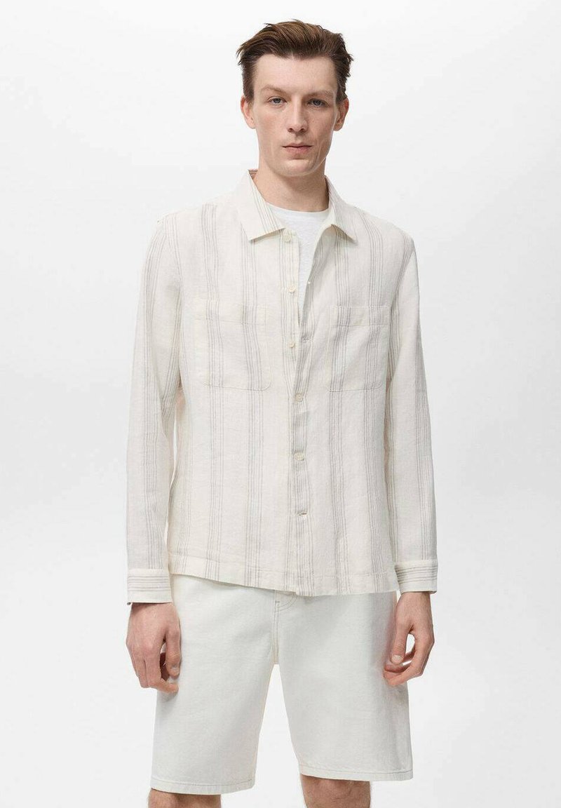 Licht beige overhemd met verticale strepen, voorzien van twee borstvo pockets en een spread collar, gecombineerd met lichte shorts.