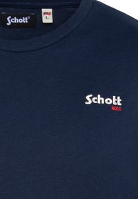T-shirt en coton bleu marine avec un col rond et un petit logo brodé "Schott N.Y.C." en blanc avec des accents rouges. Taille L.