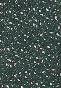 Zelená látka s výrazným vzorem leoparda, který obsahuje černé a bílé skvrny. Hladký povrch, střední gramáž a živý vzor po celé ploše.