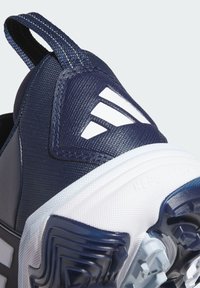 Talons de chaussure de sport bleu marine avec semelle blanche, languette de traction et motif de prise texturé, avec un détail de logo blanc à trois bandes.