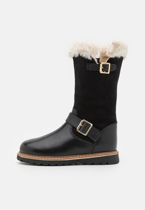Bota preta de couro e camurça com um acabamento em pelo faux, fivelas douradas e uma sola robusta. Apresenta altura até a panturrilha e detalhe de costura em contraste.