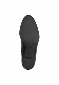 Black shoe sole with a smooth, textured surface, rounded toe, and a slight heel. Size marked as 37 on the underside.