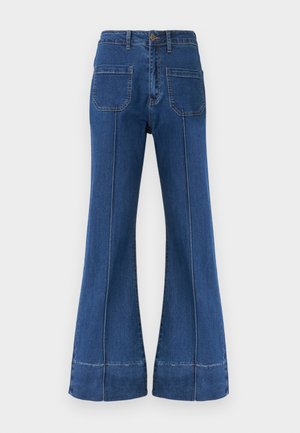 Jean en denim bleu taille haute avec jambes larges, poches plaquées à l'avant, passants pour ceinture, fermeture par bouton et détails de coutures visibles le long des jambes.
