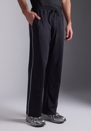 Black athletic pants with a drawstring waist, side pockets, and white side stripes. Made of soft, lightweight fabric for comfort.