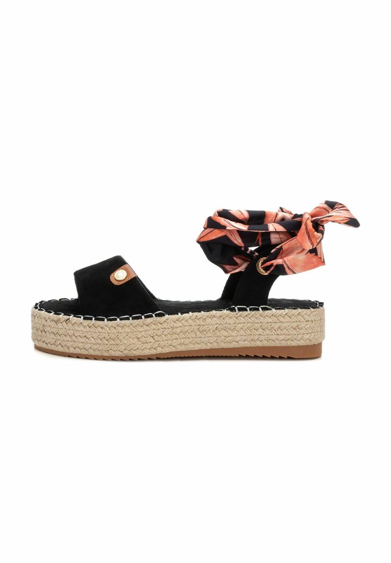 Sandalia de espadrille de ante negro con suela de yute trenzado, que presenta un lazo de tela con estampado floral naranja y costuras en contraste.