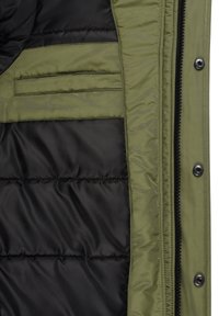 Interior de chaqueta verde oliva con forro acolchado negro, con cierre de cremallera y un bolsillo oculto en el lado izquierdo.