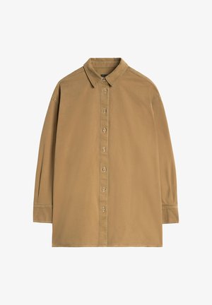 Lichtbruin overhemd met een puntkraag, lange mouwen en een knoopsluiting aan de voorkant. Heeft zichtbare stiknaden en grote knopen.