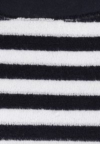 Tejido de punto con franjas alternas en negro y blanco, con una superficie suave y texturizada y un detalle de tejido visible.