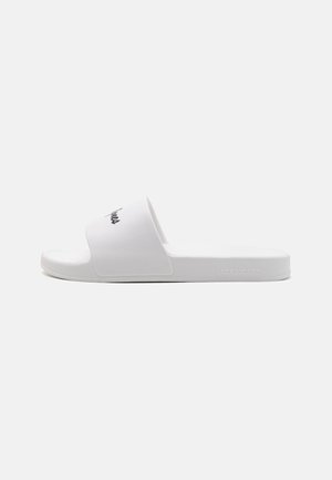 Hvit sklestøvel med en bred stropp med svart logo. Laget av glatt materiale med flat såle og minimalistisk design.