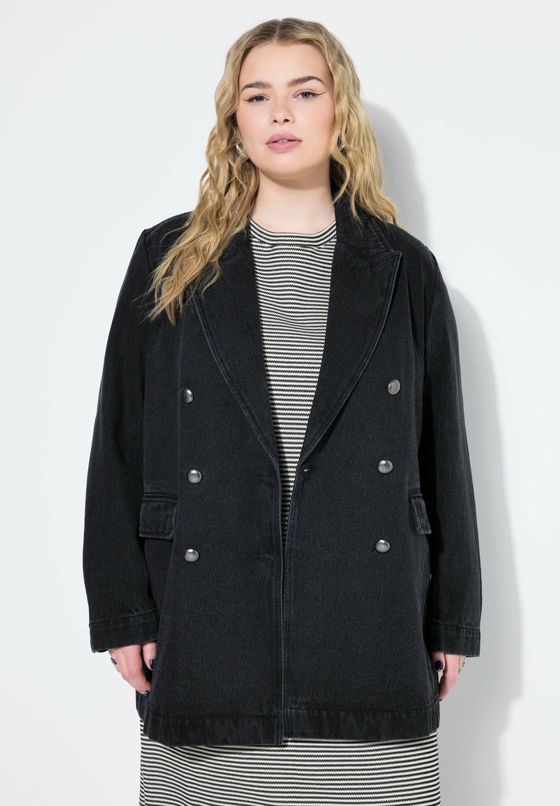 Schwarze doppelte Denim-Jacke mit silbernen Knöpfen, breiten Revers und aufgesetzten Taschen, getragen über einem gestreiften Oberteil. Strukturiertes Material.