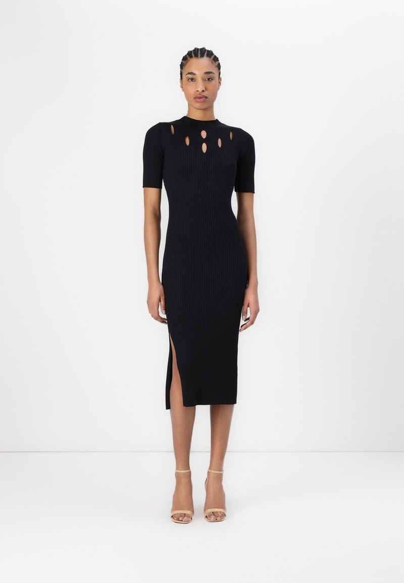 Svart ribbad midiklänning med korta ärmar, med utskurna detaljer vid halsringningen och en sidslits. Slät textur och figurnära design.