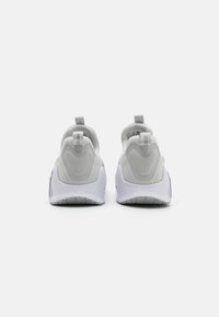 Scarpe sportive grigie con una tomaia liscia, tacco imbottito e suola texturizzata. Presentano linguette per una facile calzata e dettagli di design senza cuciture.