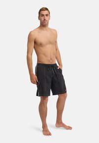 Μαύρα μαγιό σορτς με κορδόνι στη μέση, πλαϊνή τσέπη, αντίθετες ραφές και λεπτομέρειες στο τελείωμα. Σχεδιασμένα σε άνετη εφαρμογή για μεγαλύτερη άνεση.
