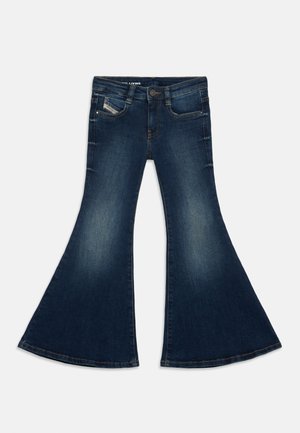 Vaqueros de mezclilla azul oscuro con cintura alta y piernas anchas acampanadas, con bolsillos delanteros y desgaste en los muslos y las rodillas.
